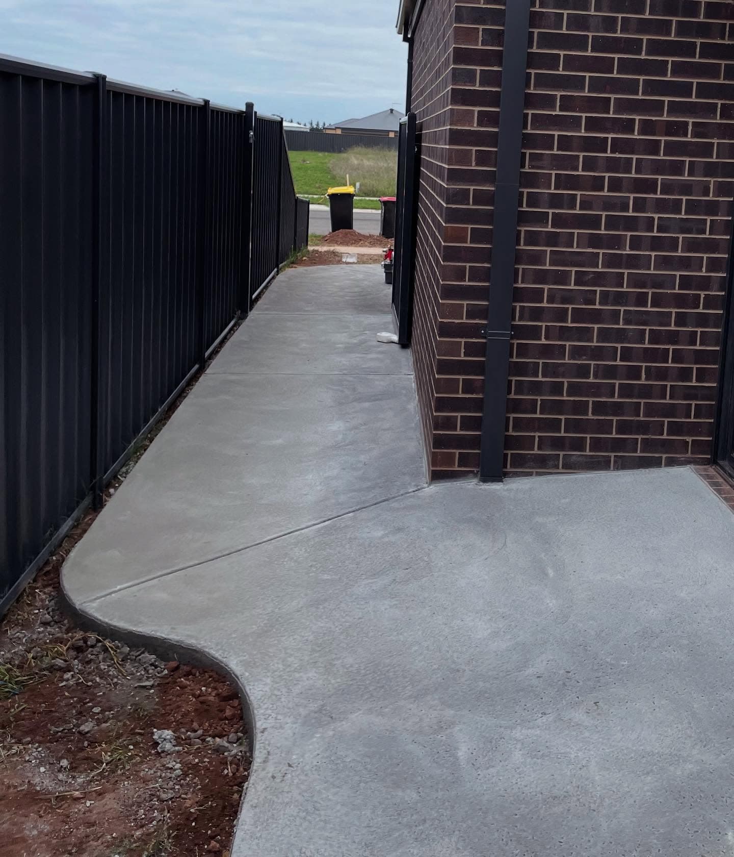 Finished concrete house surround and path wrapping a new brick home, Sale